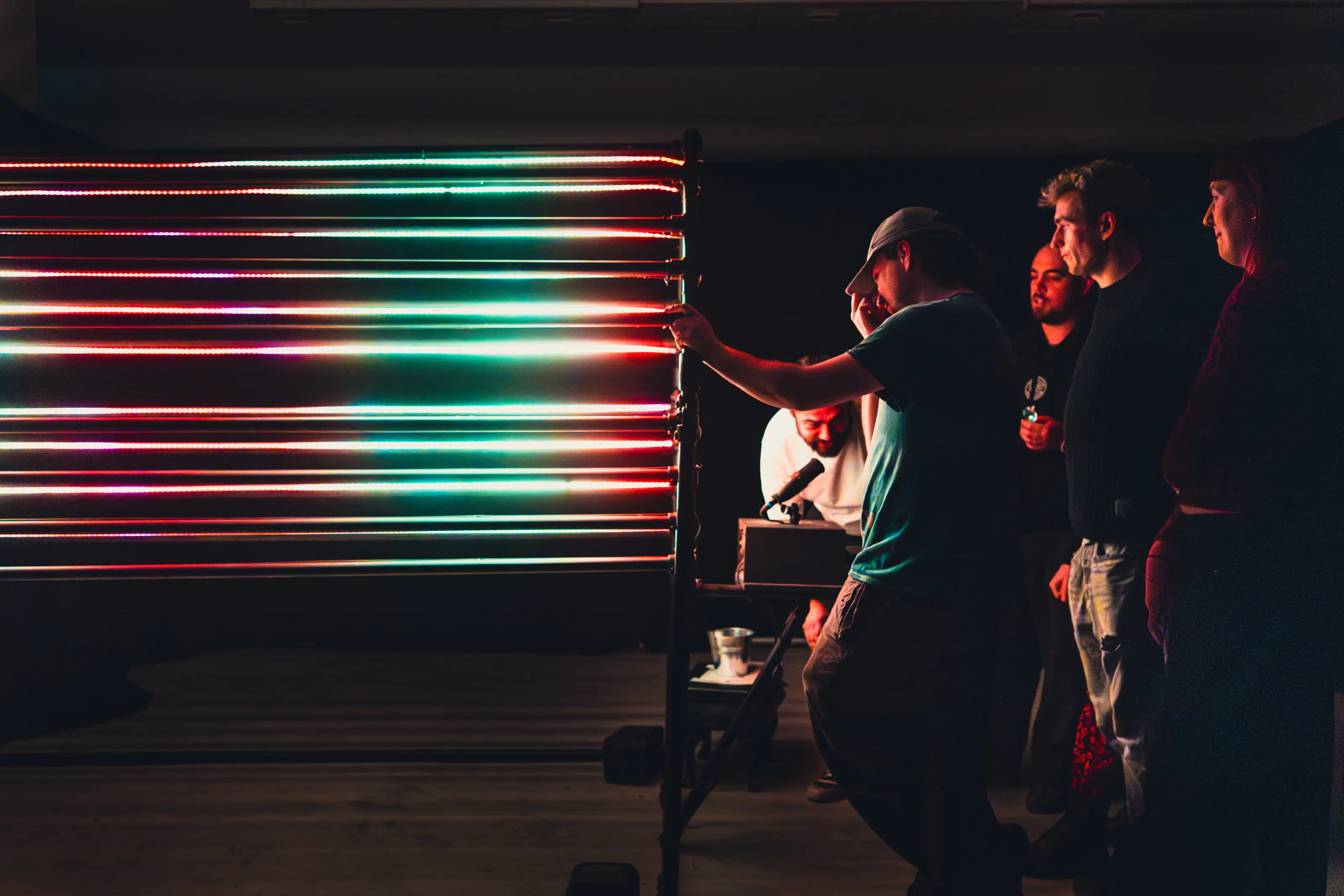 Audience member interacting with the illuminated AI sculpture as light pulses radiate outward