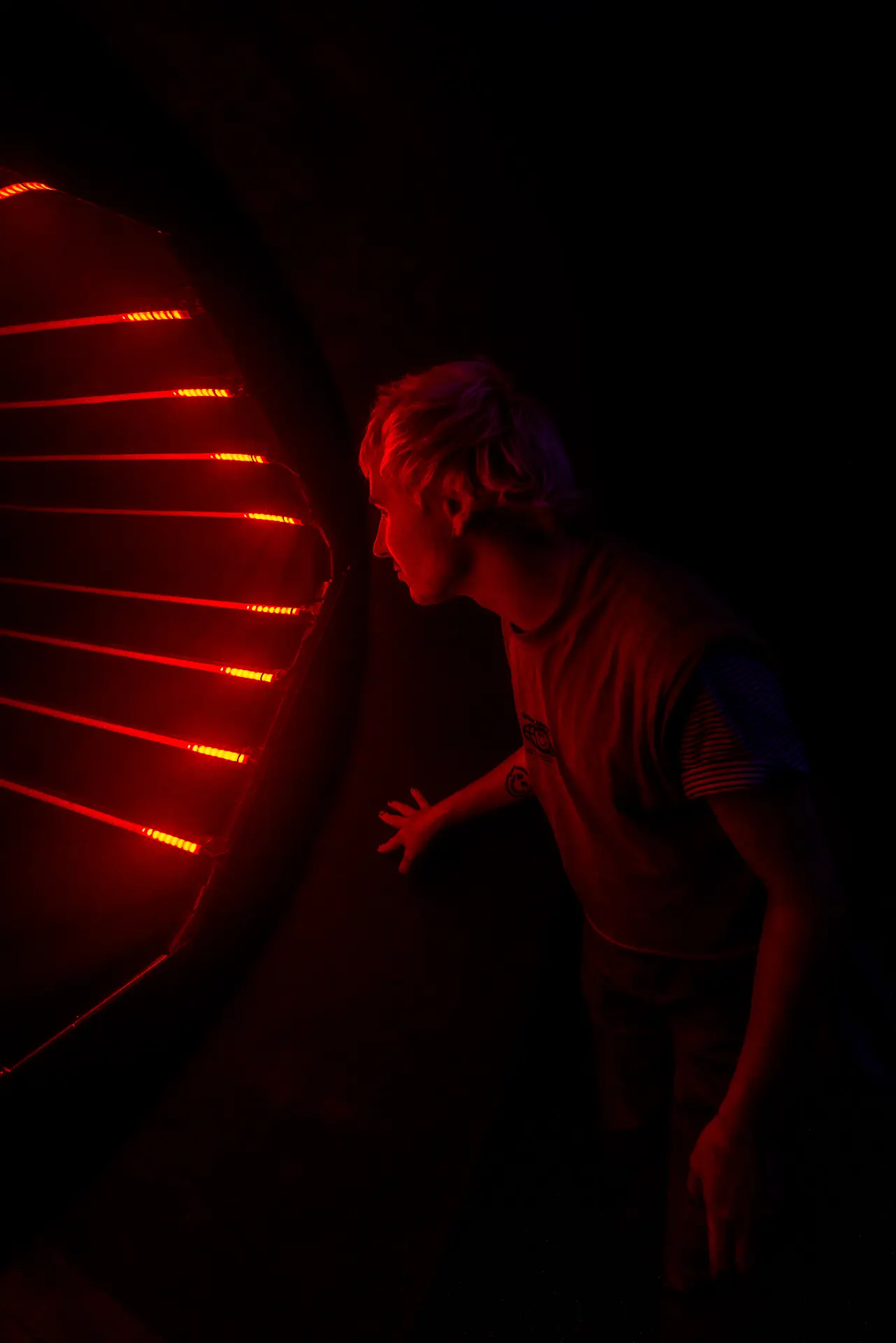 Visitor standing in front of a glowing red circular interface while speaking to the AI entity
