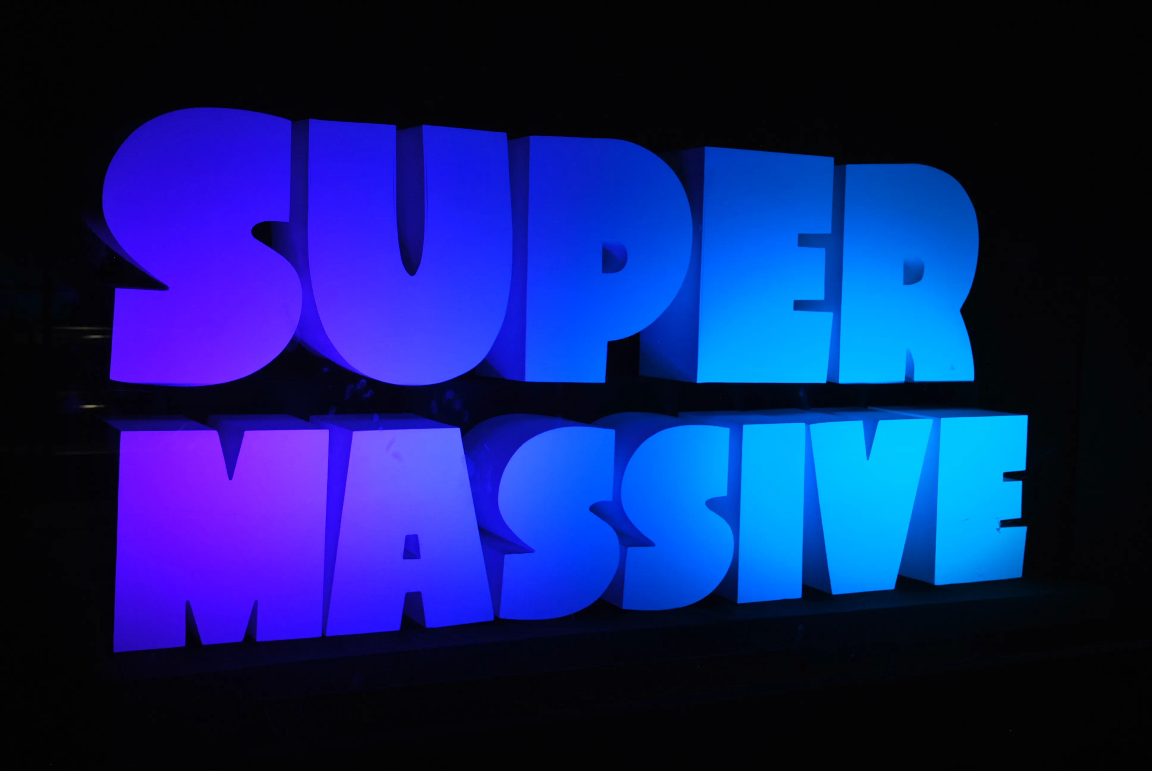 SUPERMASSIVE logo reflected in a Salford window