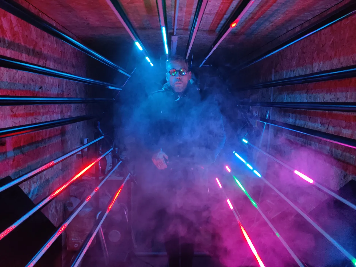 A man standing in a light installation tunnel